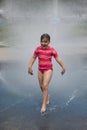 Little girl in sun suit running in childrenÃ¢â¬â¢s park water games Royalty Free Stock Photo
